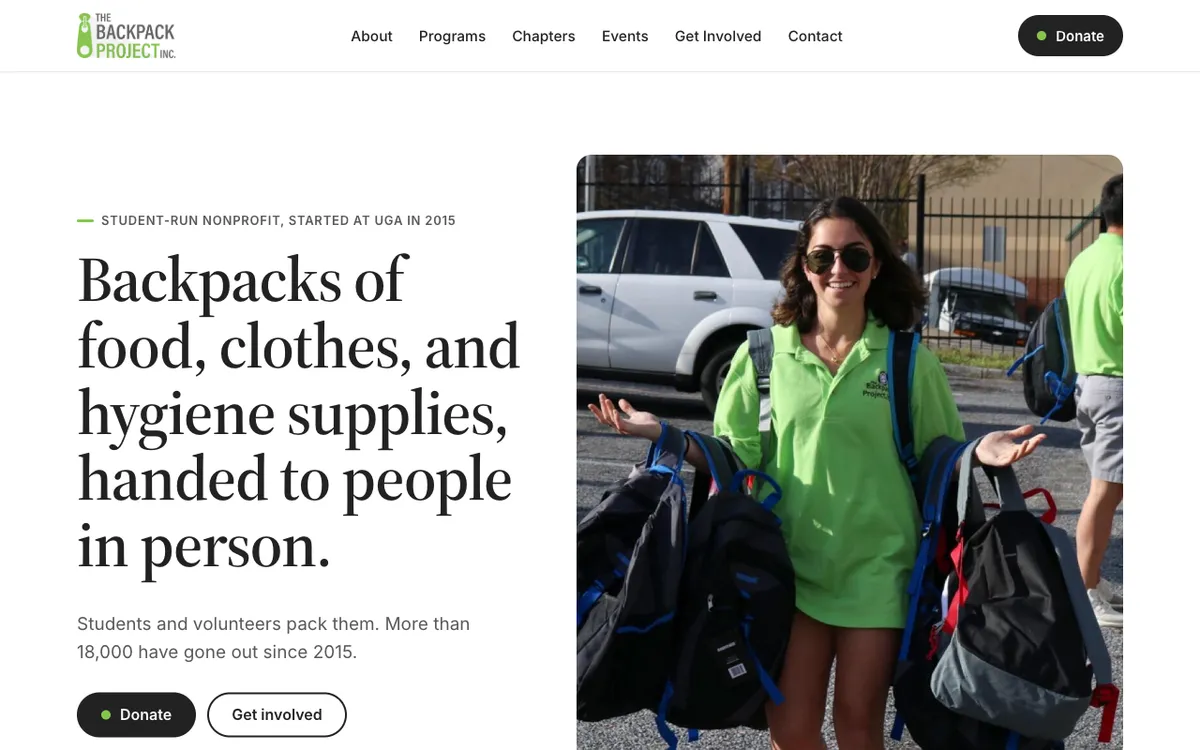 The Backpack Project homepage: a volunteer holding backpacks beside the headline about food, clothes, and hygiene supplies